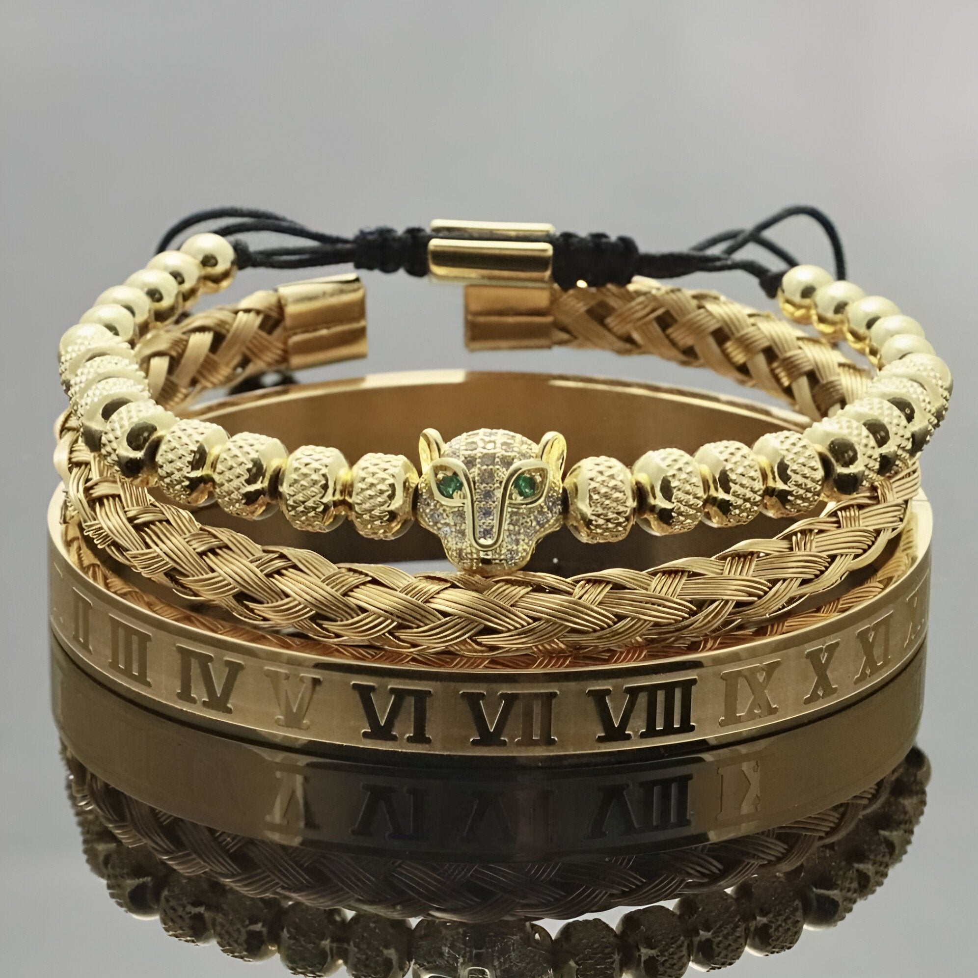 Trio de bracelets homme en acier inoxydable or, motif tête de léopard avec yeux verts, maillons tressés et bracelet lisse.