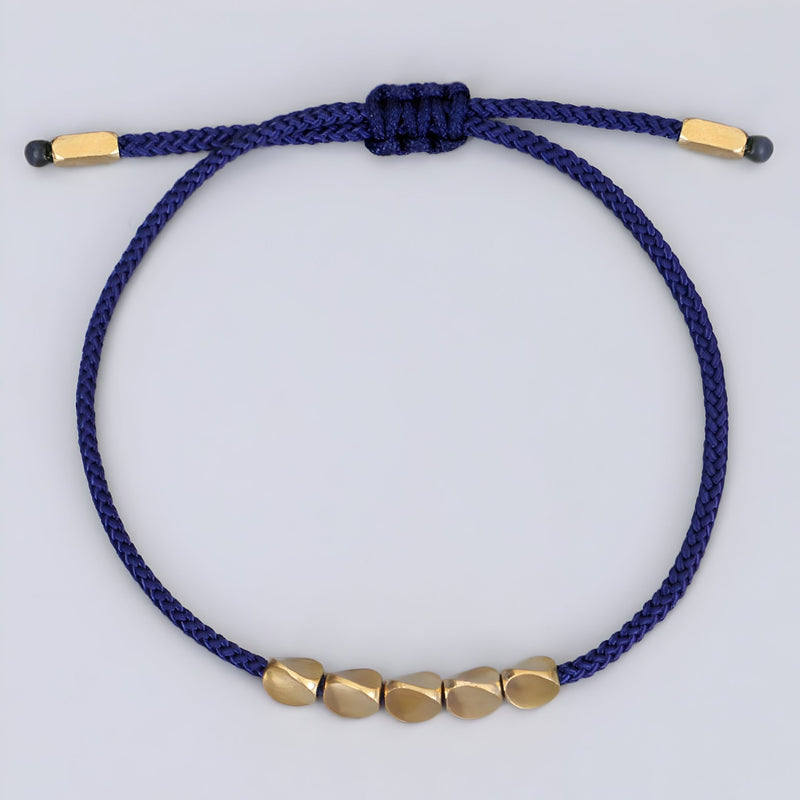 Bracelet tibétain bleu en corde avec cinq perles en cuivre doré, modèle Dolma pour femme.