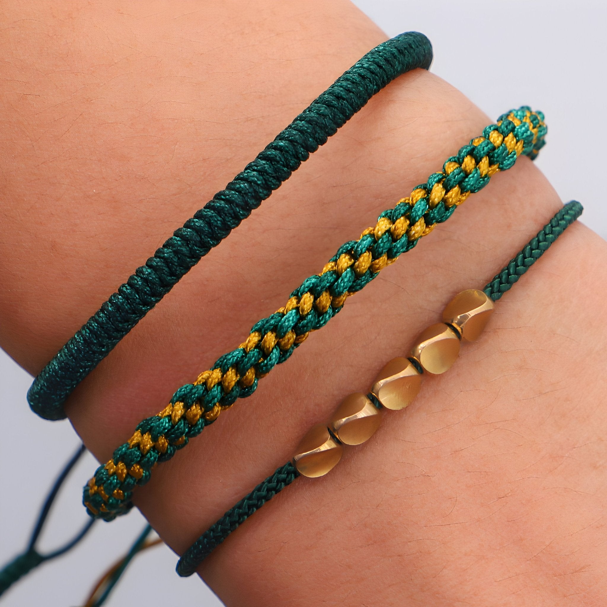 Trio de bracelets tibétains verts en corde tressée et perles de cuivre hexagonales.