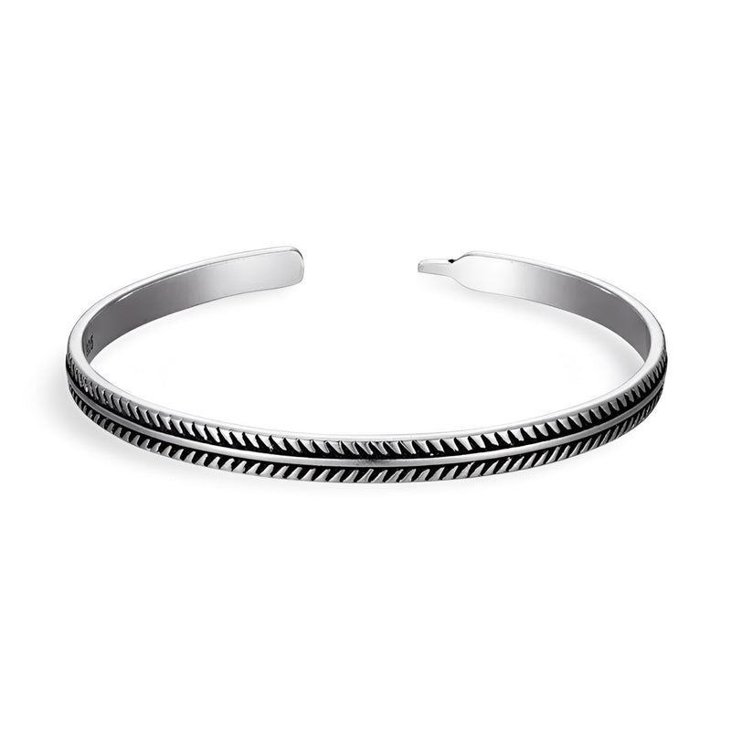 Bracelet ouvert en cuivre argenté avec motif chevrons noirs gravés, style tibétain élégant.