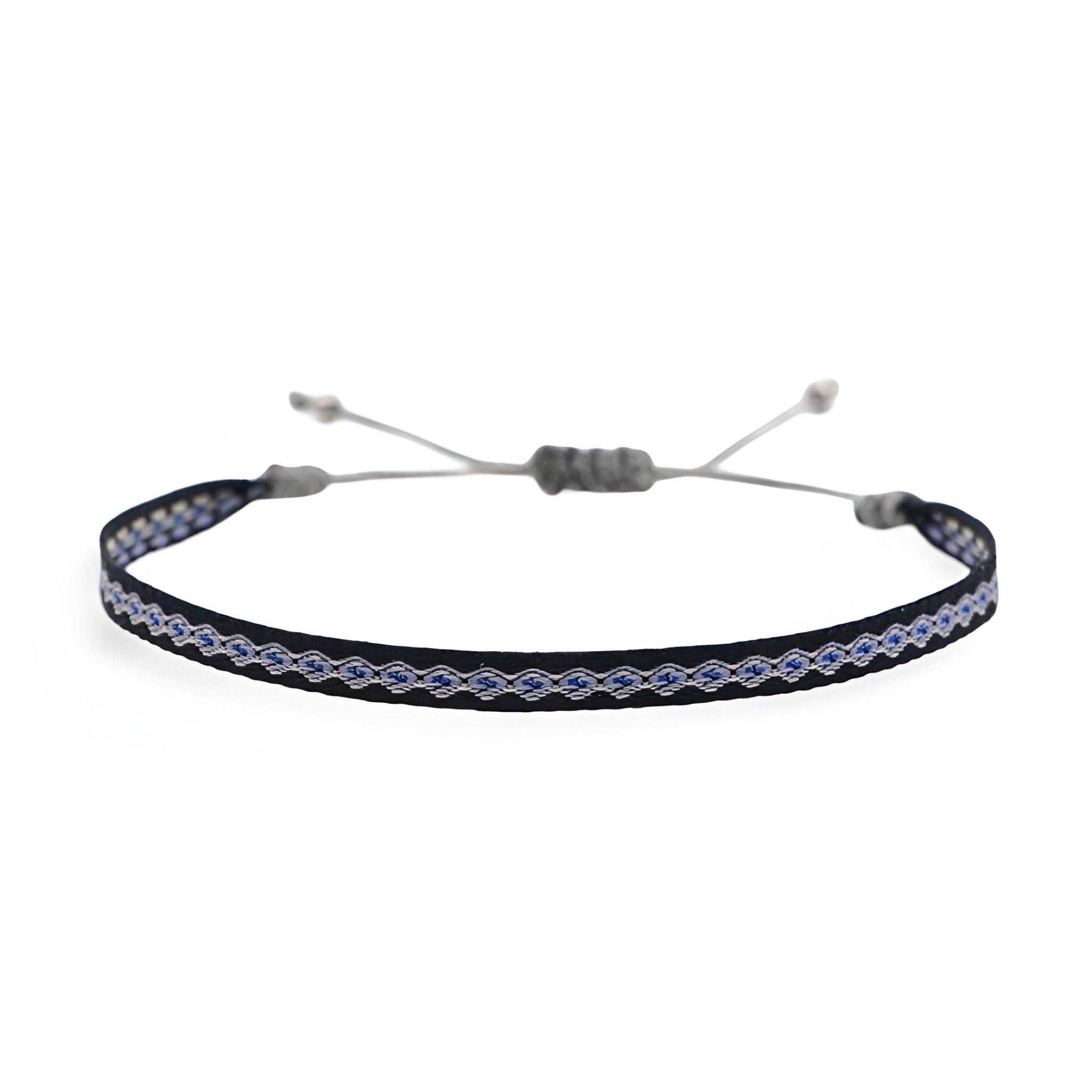 Bracelet tibétain pour homme en coton noir et blanc avec corde ajustable et détails en cuivre.