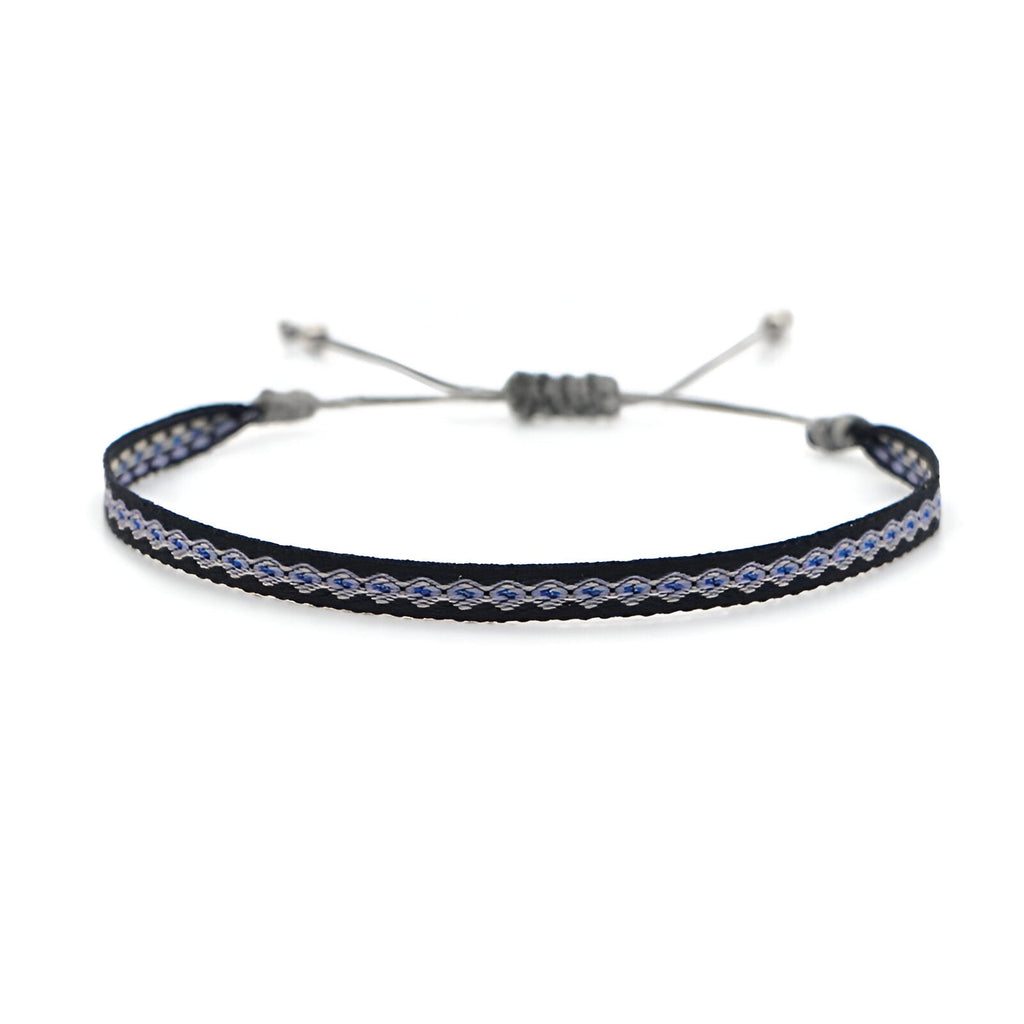 Trio de bracelets tibétains noirs en coton tressé avec détails argent et fermeture coulissante.