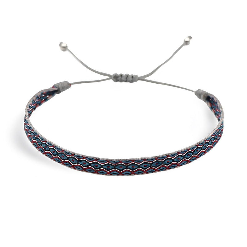 Bracelet tibétain Patricio en coton bleu et rouge avec motifs géométriques et fermoir coulissant gris.