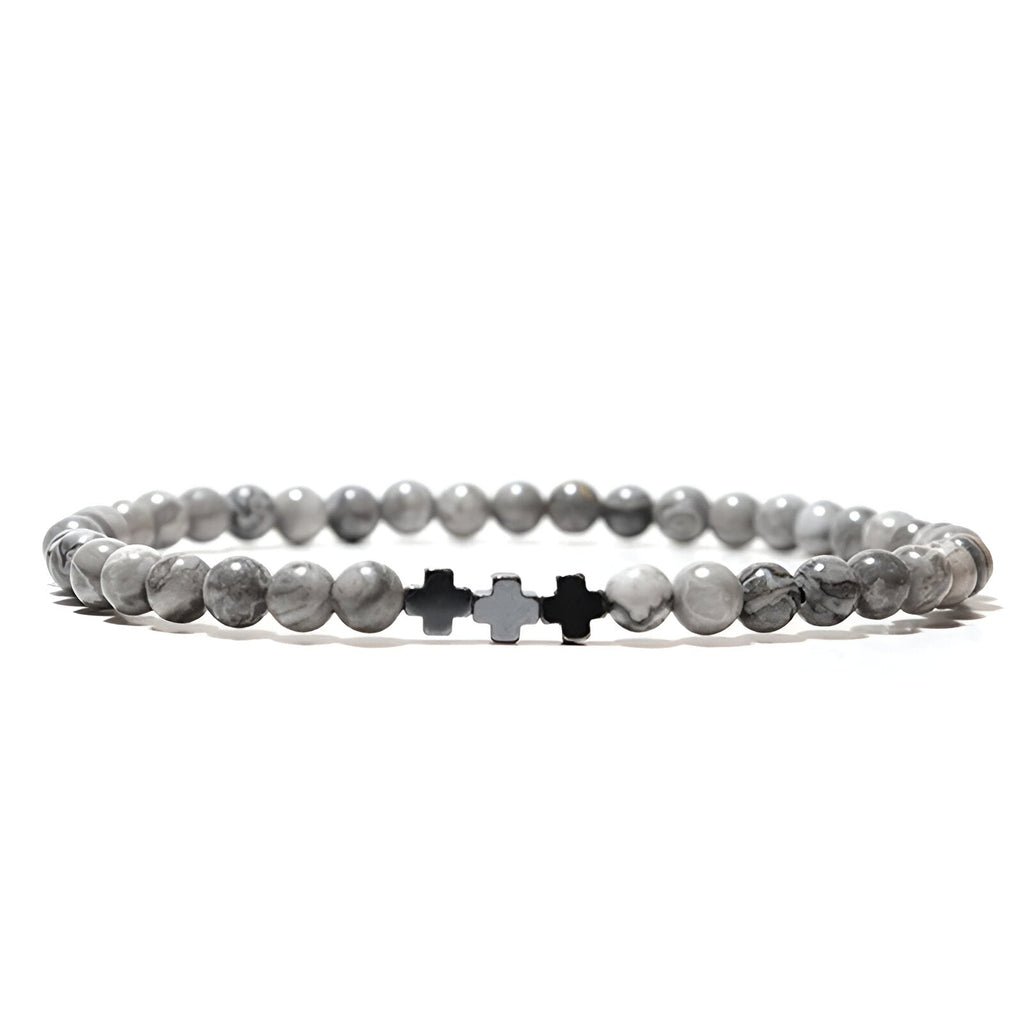 Trio de bracelets tibétains gris en perles de jaspe et croix en argent sur fond blanc.