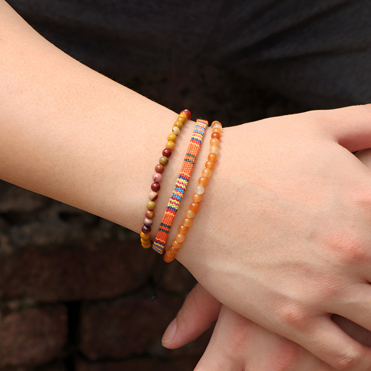 Trio de bracelets tibétains pour homme en jaspe rouge et perles multicolores sur poignet.