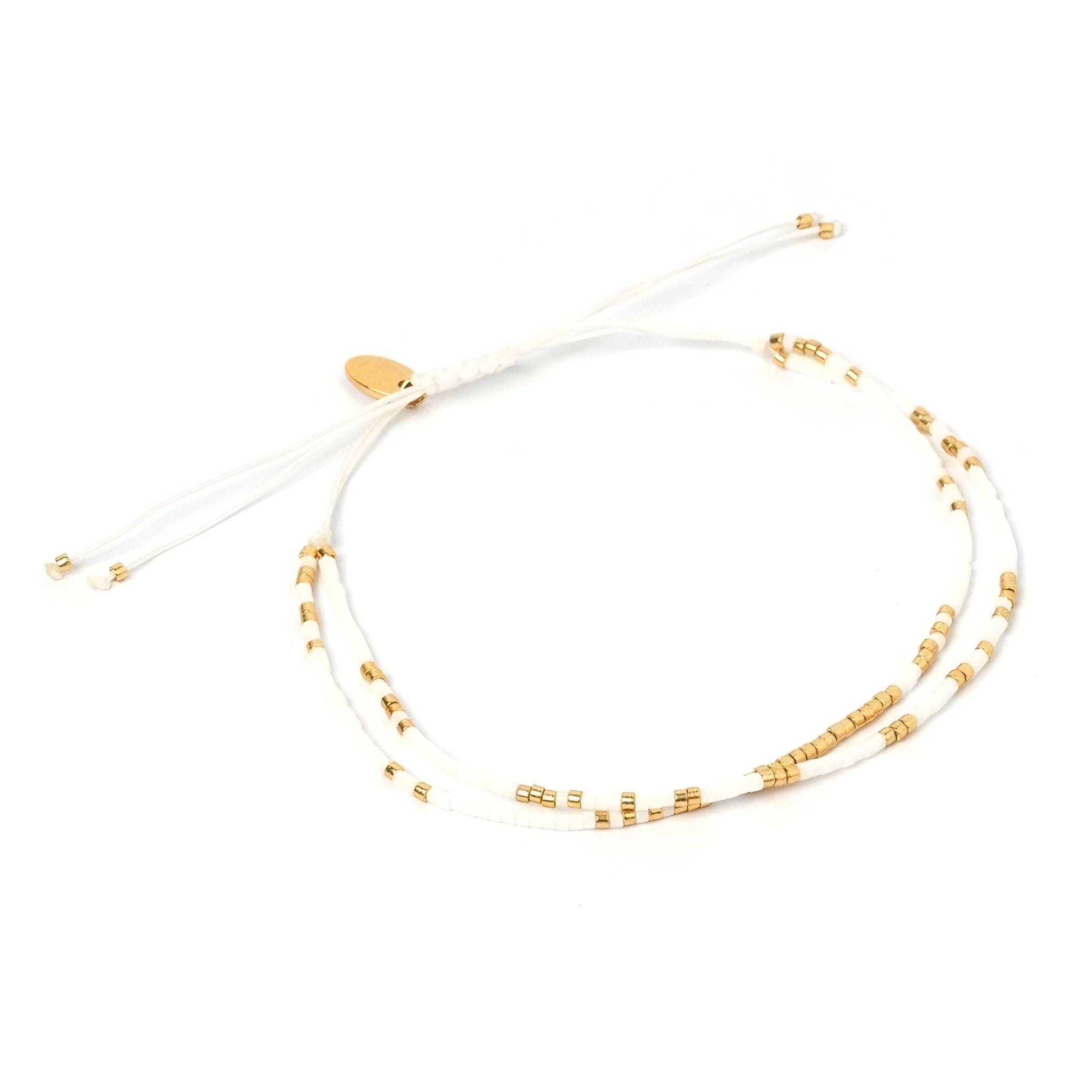 Bracelet fin à perles blanches et dorées double rang avec fermoir coulissant or.