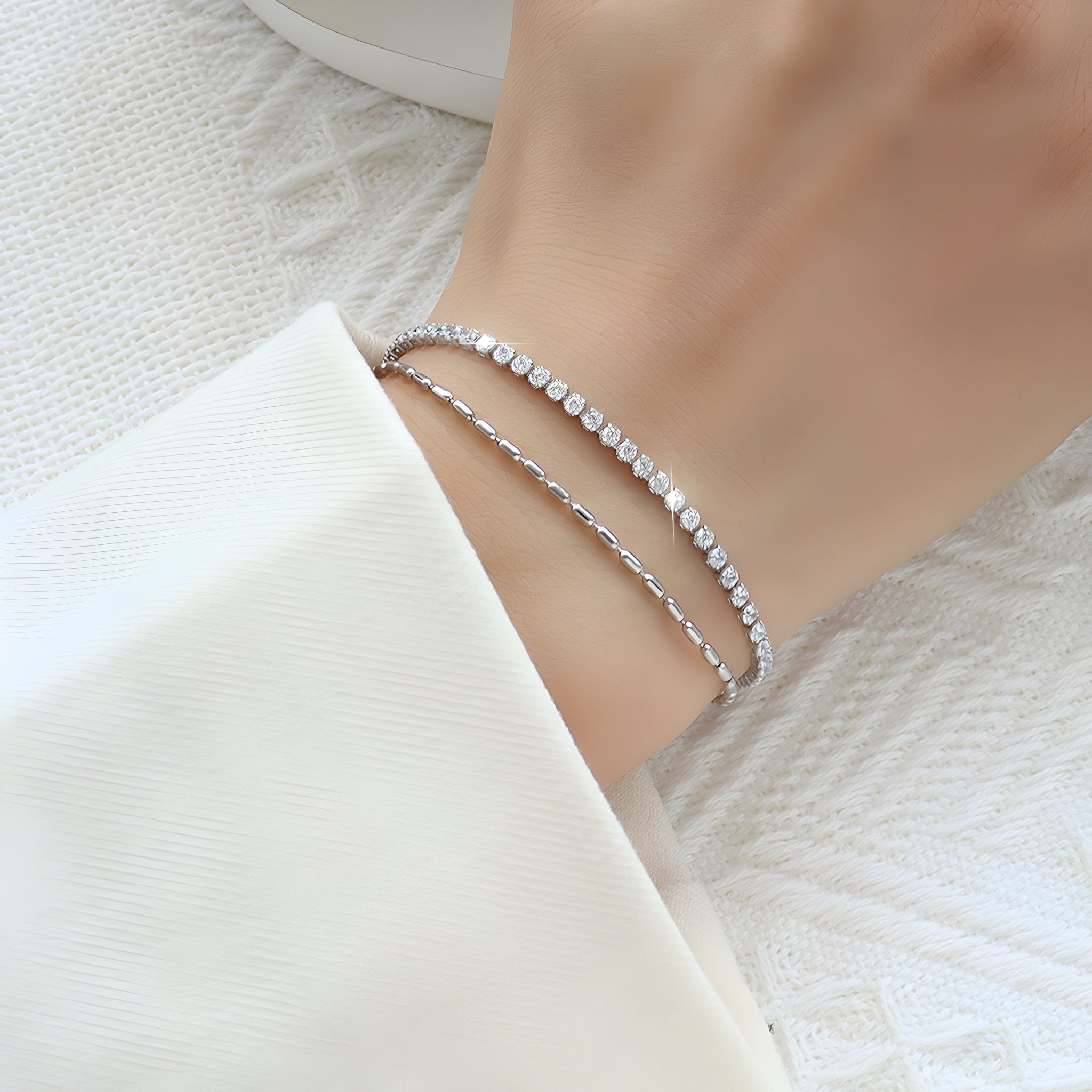 Bracelet double chaîne en titane argenté avec pierres scintillantes, style élégant féminin.