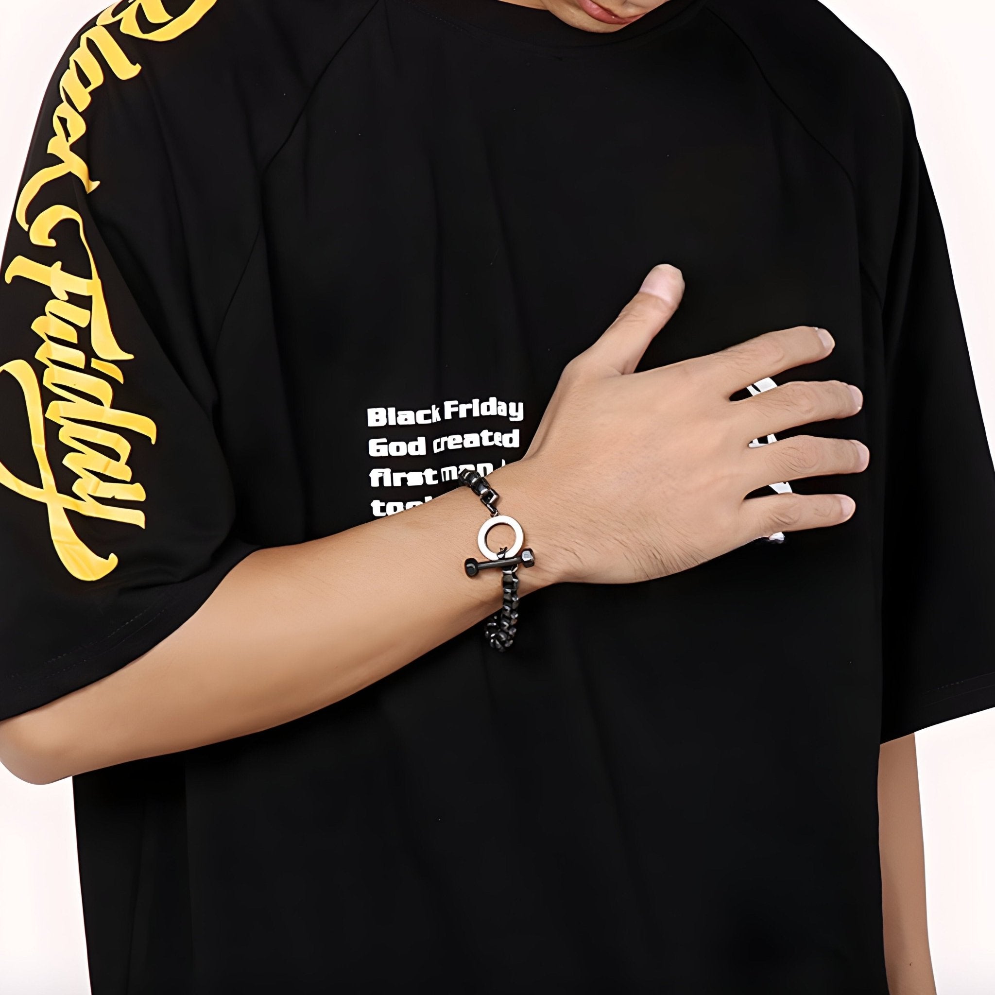 Bracelet homme en acier inoxydable noir avec charm haltère, fermoir rond design moderne.