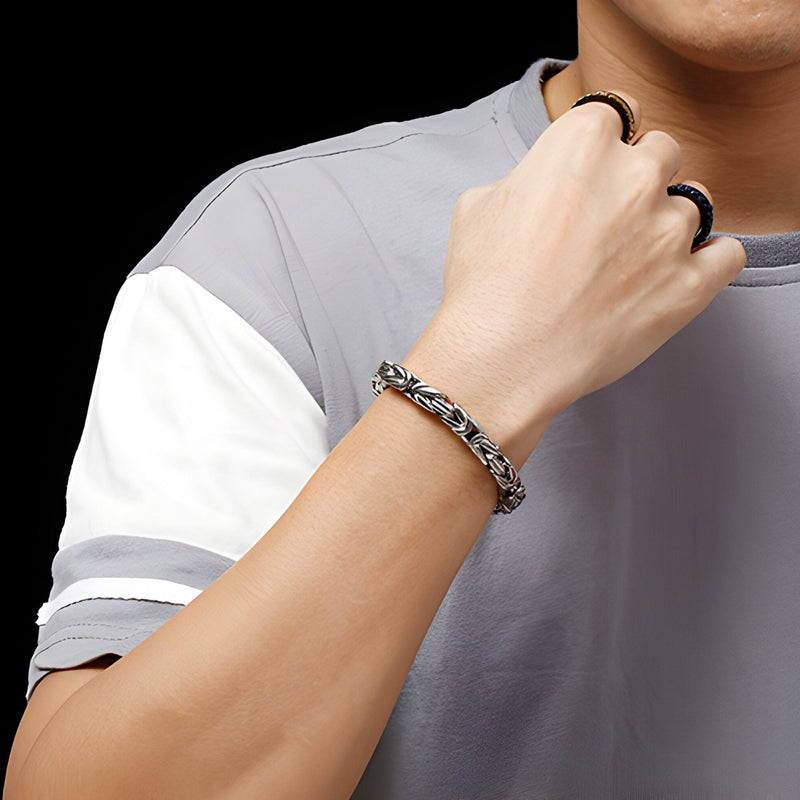 Bracelet homme en acier inoxydable argenté maille cubaine porté au poignet, style moderne.