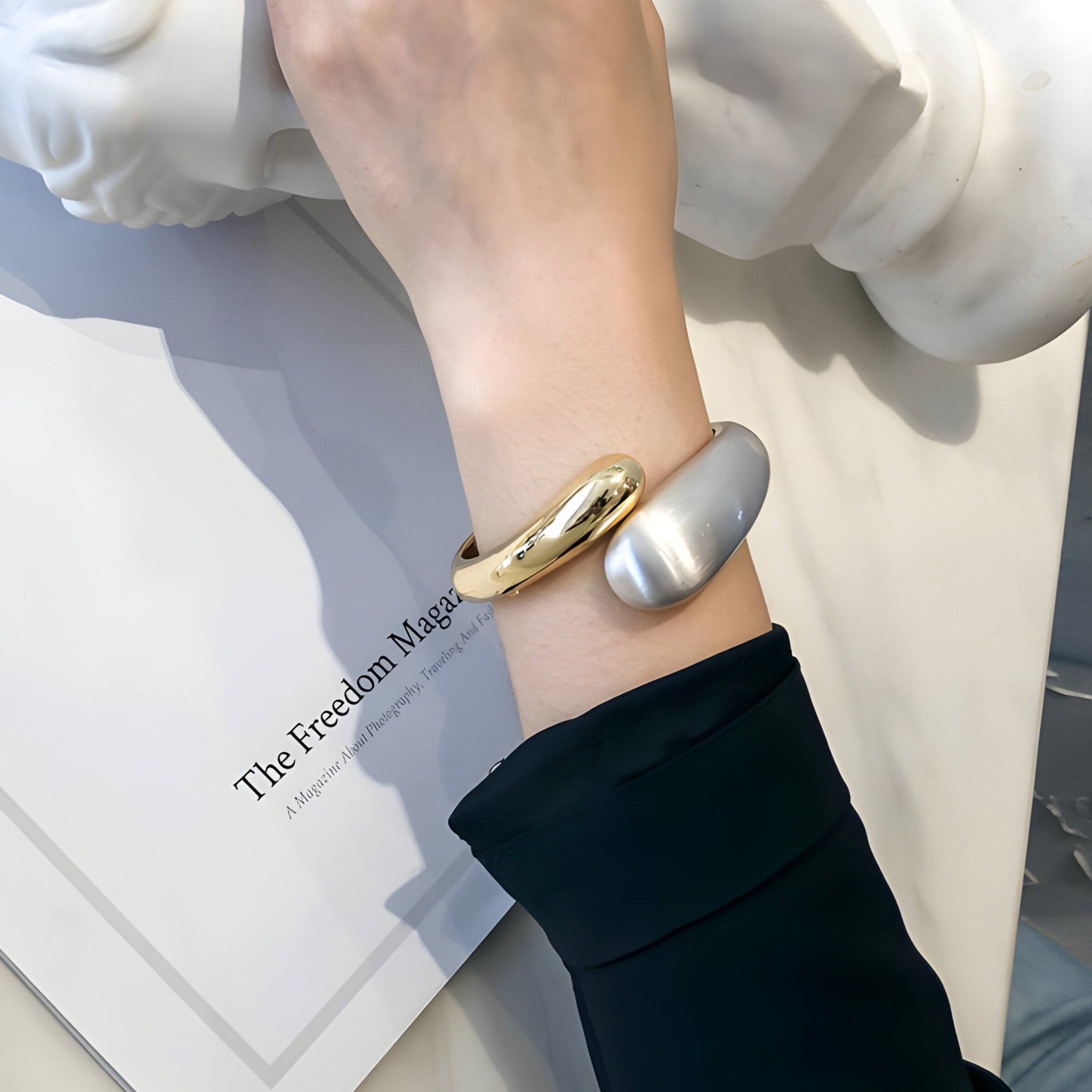 Bracelet jonc à ressort plaqué or jaune et argent mat, style épuré et moderne.