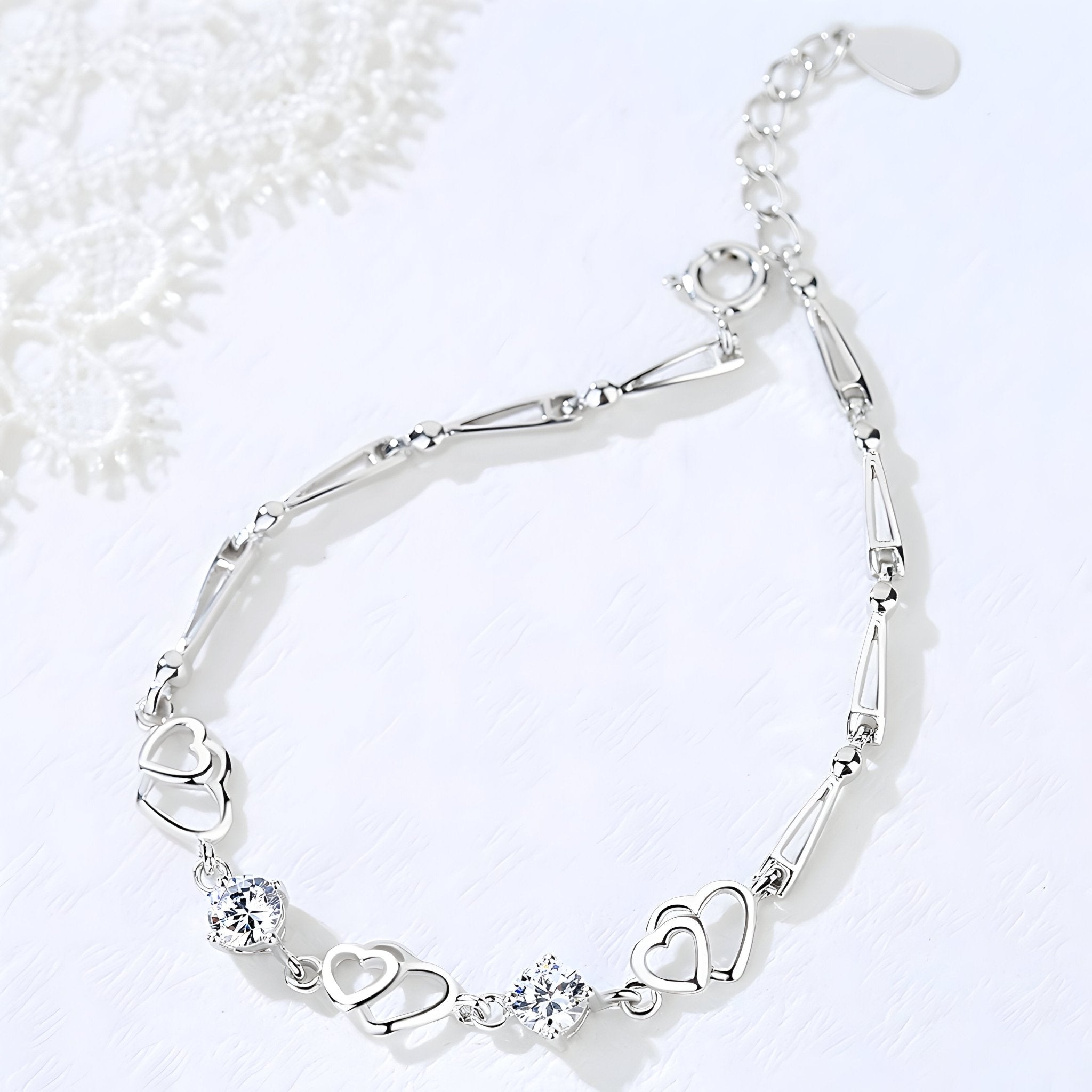 Bracelet argent massif femme avec charms cœurs et éclats brillants design élégant.