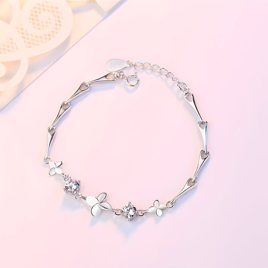 Bracelet en argent massif avec pendentifs trèfle à quatre feuilles et petites fleurs délicates.