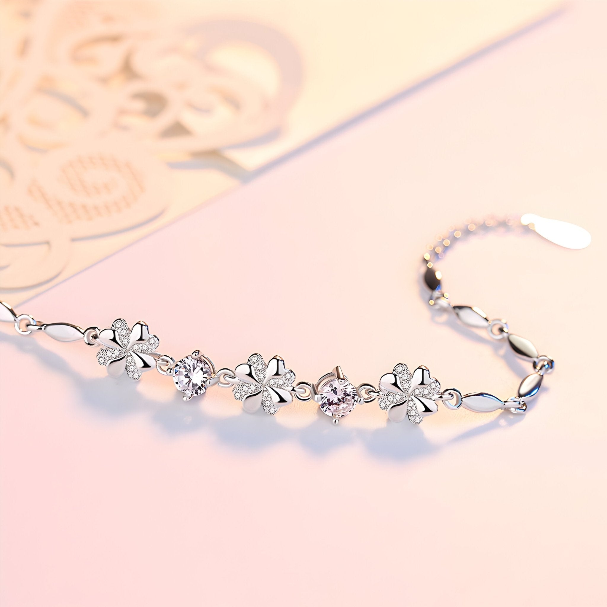 Bracelet fin en argent avec cinq trèfles à quatre feuilles délicats et petits liens chaînes.