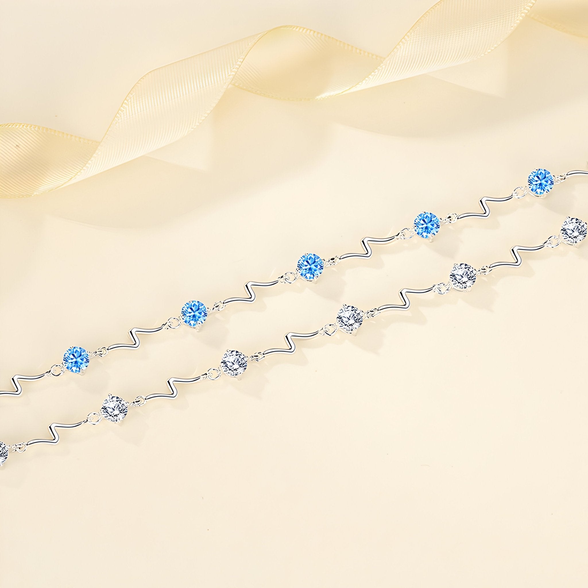 Bracelet fin en argent sterling avec perles bleues et argentées, design ondulé élégant.