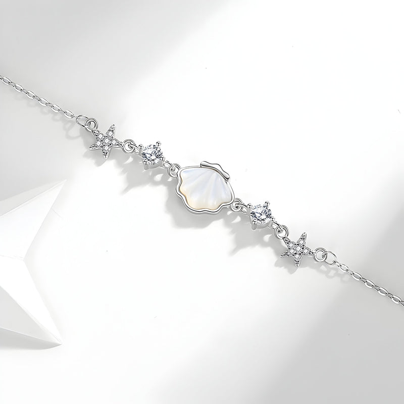 Bracelet en argent sterling avec pendentifs coquillage nacré et étoiles de mer délicates.