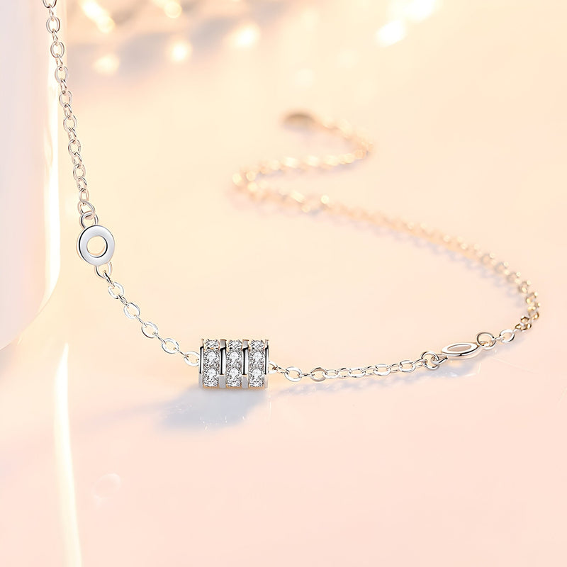 Bracelet fin en argent sterling avec charm cylindrique orné de petits cristaux brillants.