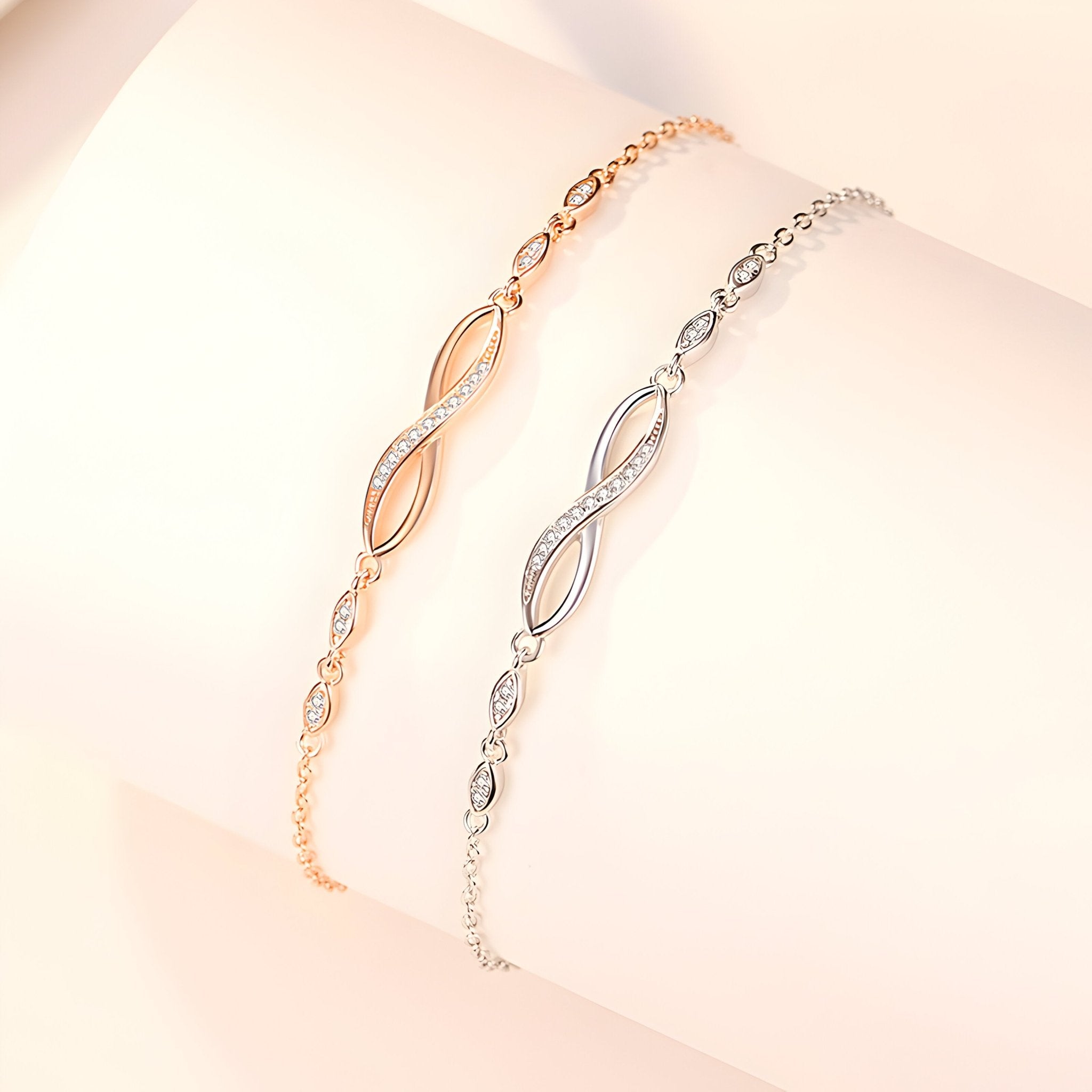 Deux bracelets féminins en argent sterling et or, charms infini incrustés de petites pierres scintillantes, design délicat.