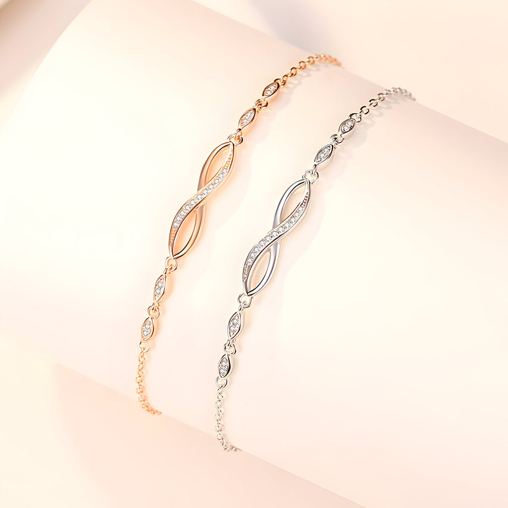 Deux bracelets féminins en argent sterling et or, charms infini incrustés de petites pierres scintillantes, design délicat.