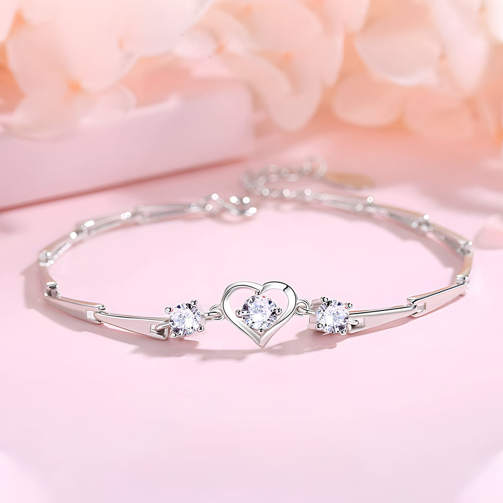 Bracelet femme en argent sterling avec cœur central orné de pierres et chaîne fine brillante.