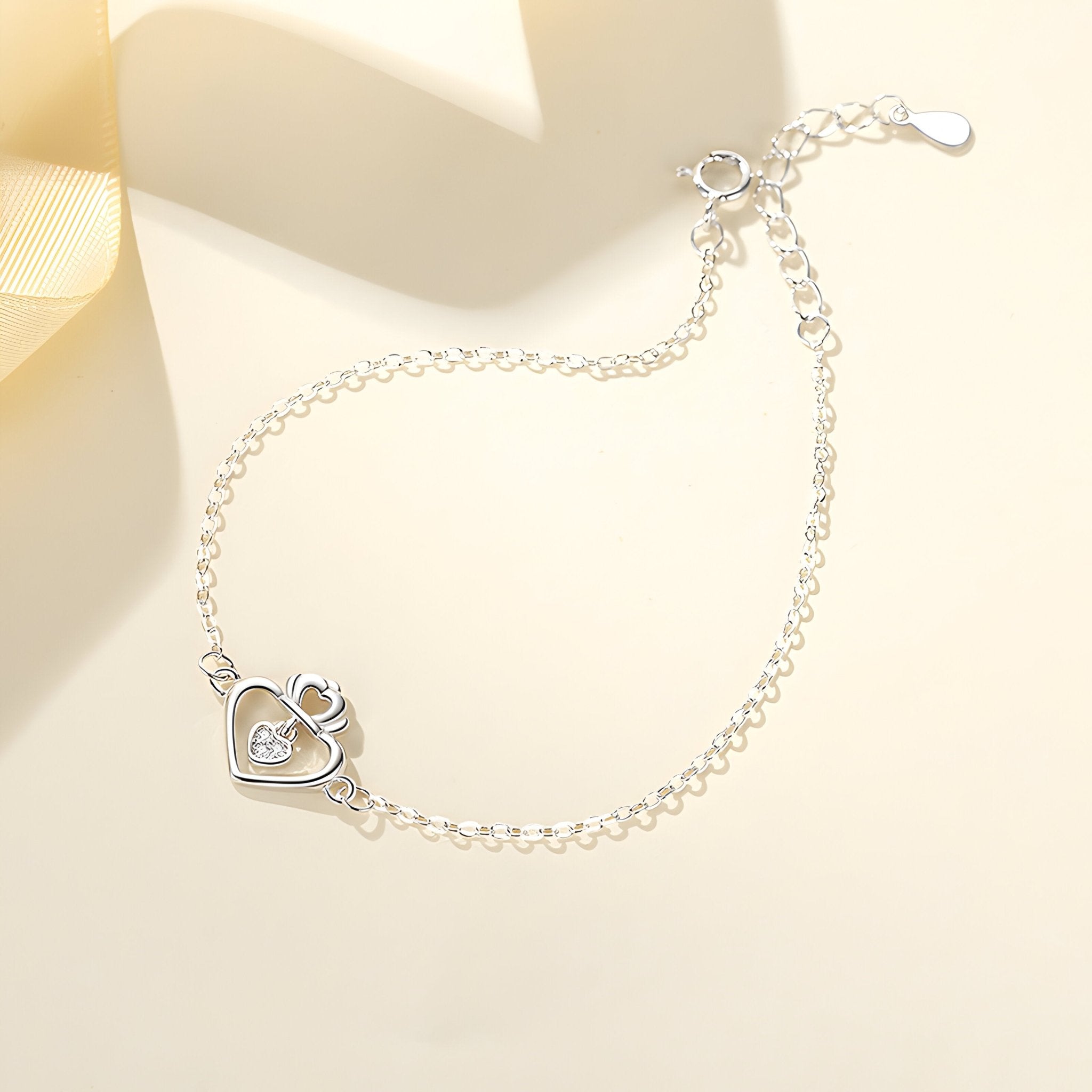 Bracelet en argent sterling avec pendentif cœur ajouré et petit diamant central, chaîne fine ajustable.