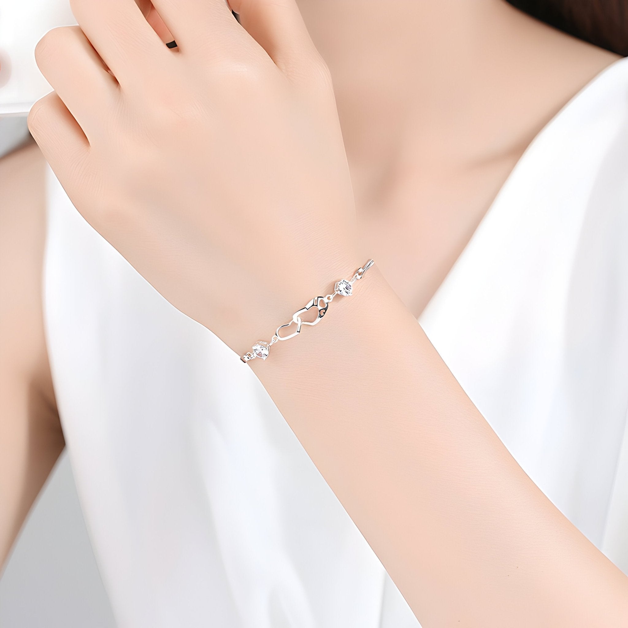 Bracelet fin en argent sterling avec petits cœurs difformes suspendus, style délicat et féminin.