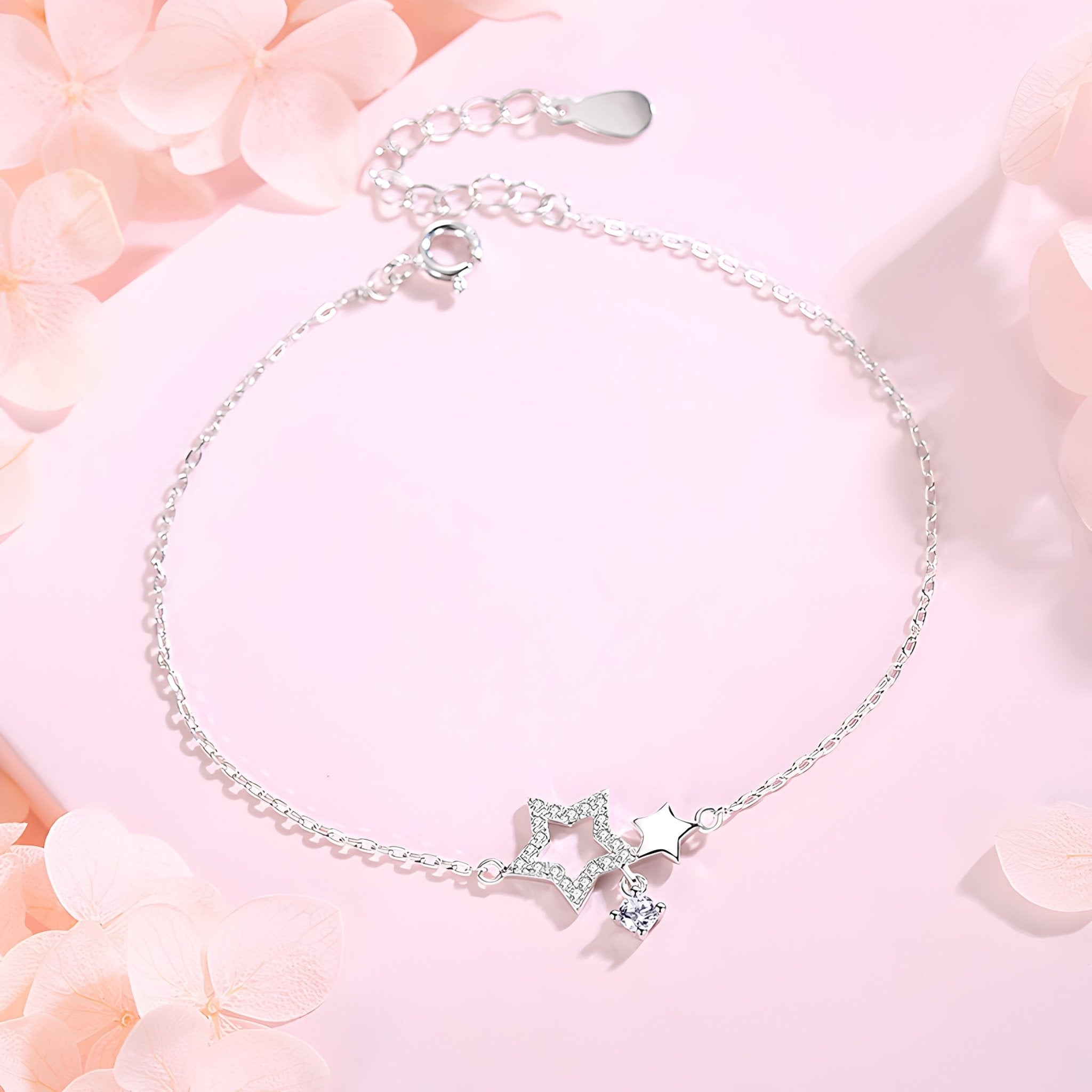 Bracelet fin en argent sterling avec double pendentif étoiles et chaîne délicate.