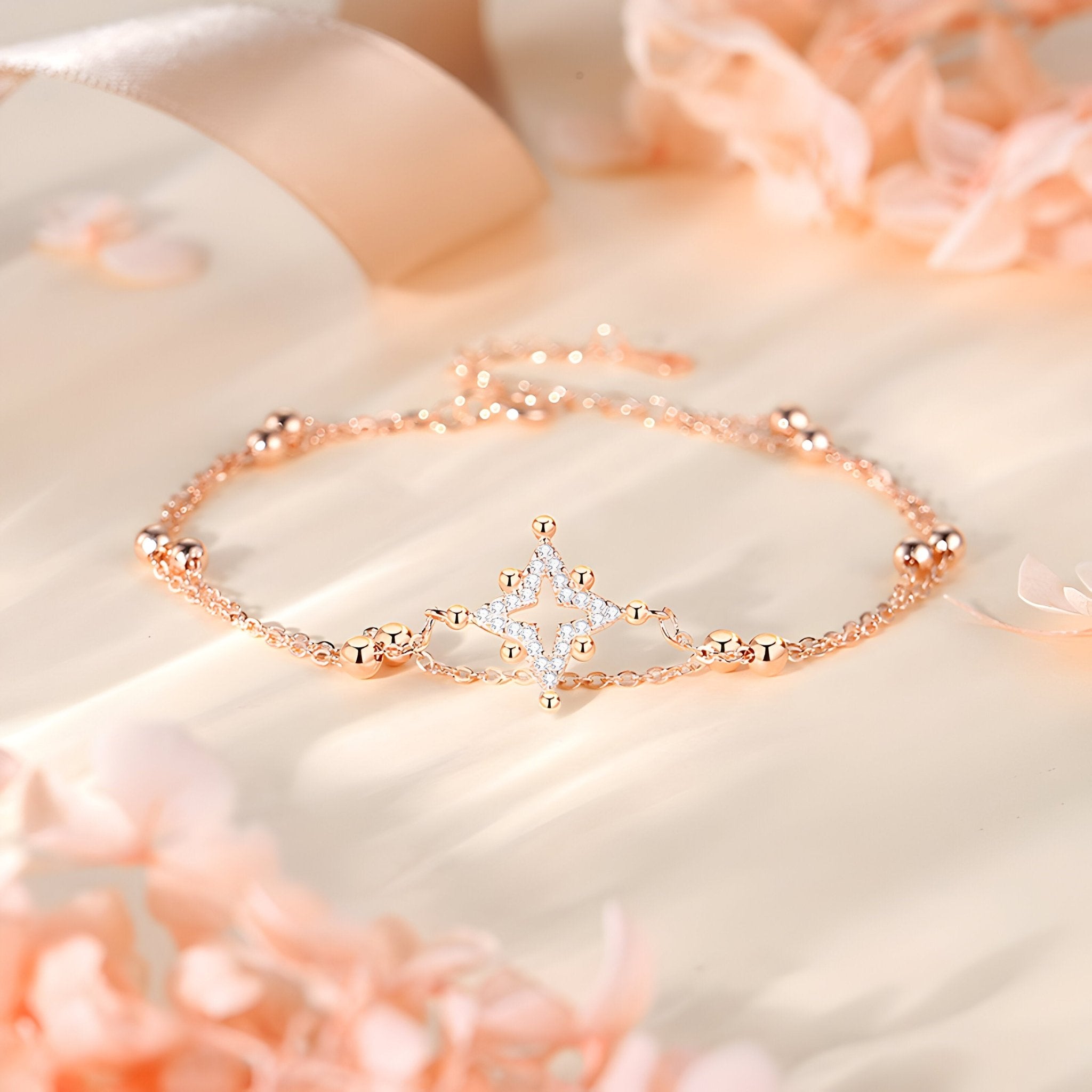 Bracelet fin en argent rosé avec étoile ornée de petites pierres brillantes.