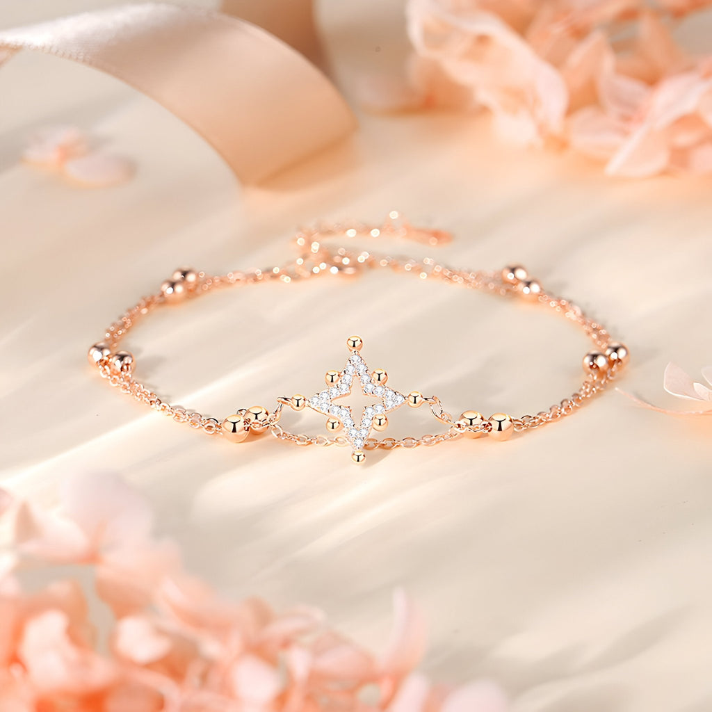 Bracelet fin en argent rosé avec étoile ornée de petites pierres brillantes.