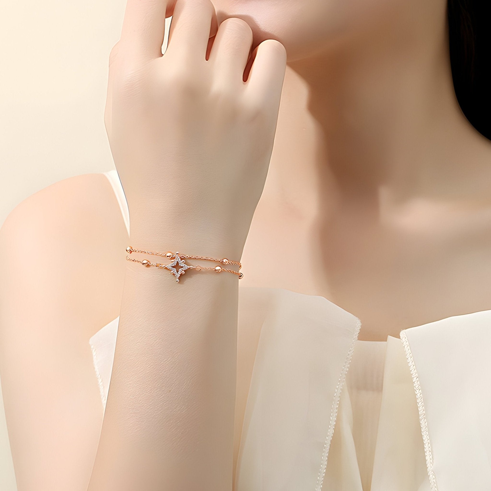 Bracelet en argent rosé avec étoile centrale et chaîne fine portée au poignet féminin.
