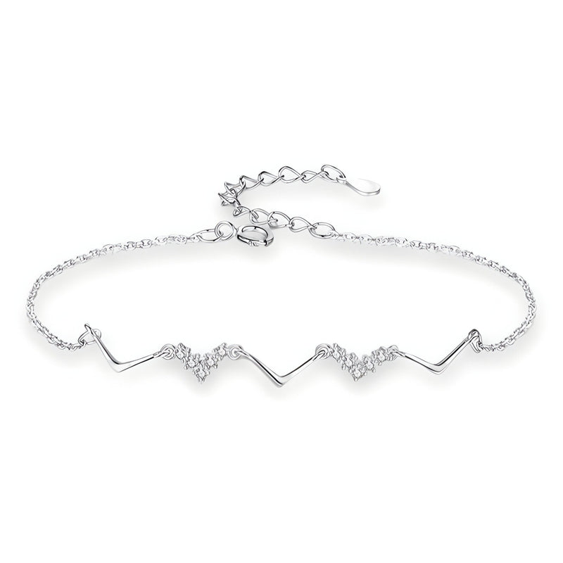Bracelet fin en argent sterling avec motif symétrique ondulé et détails scintillants.