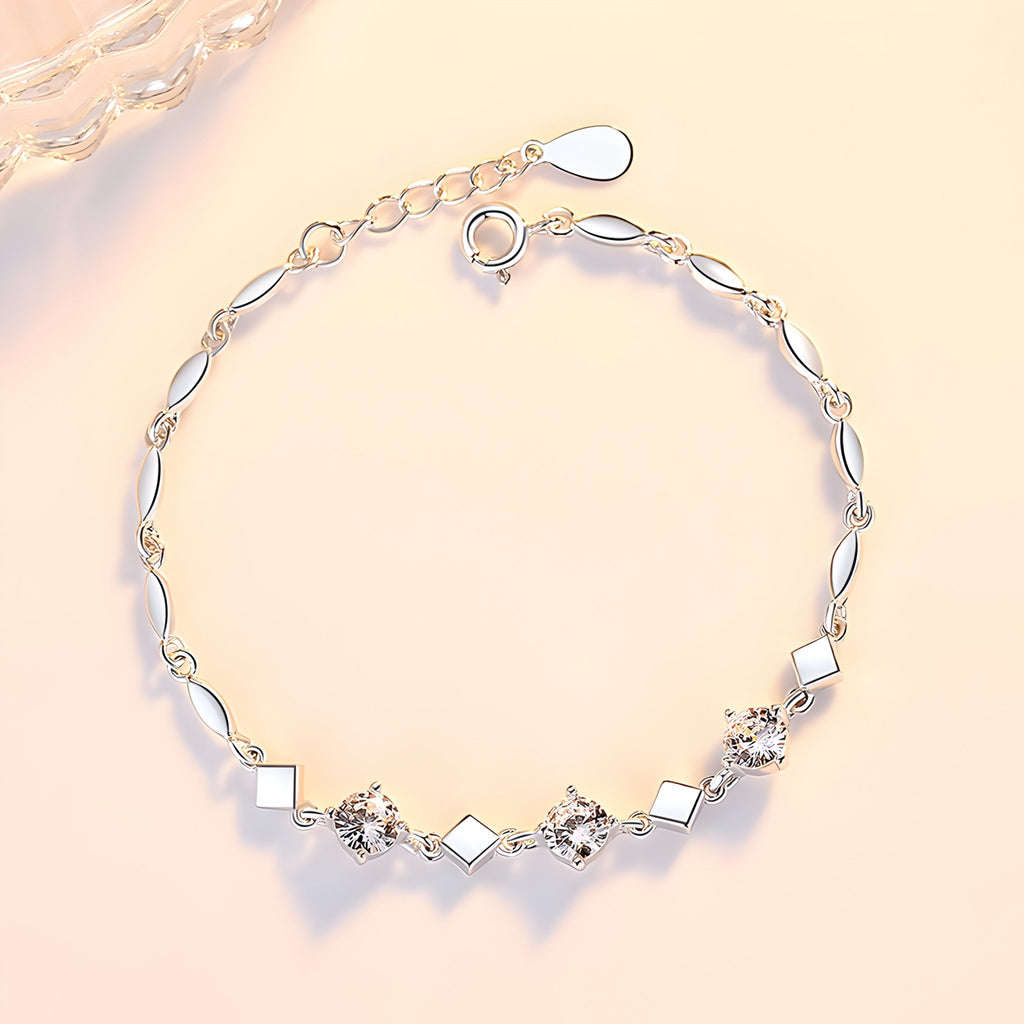Bracelet argent sterling femme avec maillons géométriques carrés et fleurs délicates.