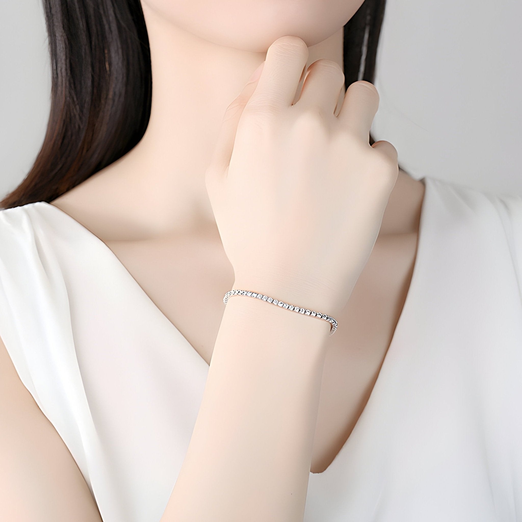 Bracelet fin en argent sterling à maille vénitienne, porté au poignet féminin.