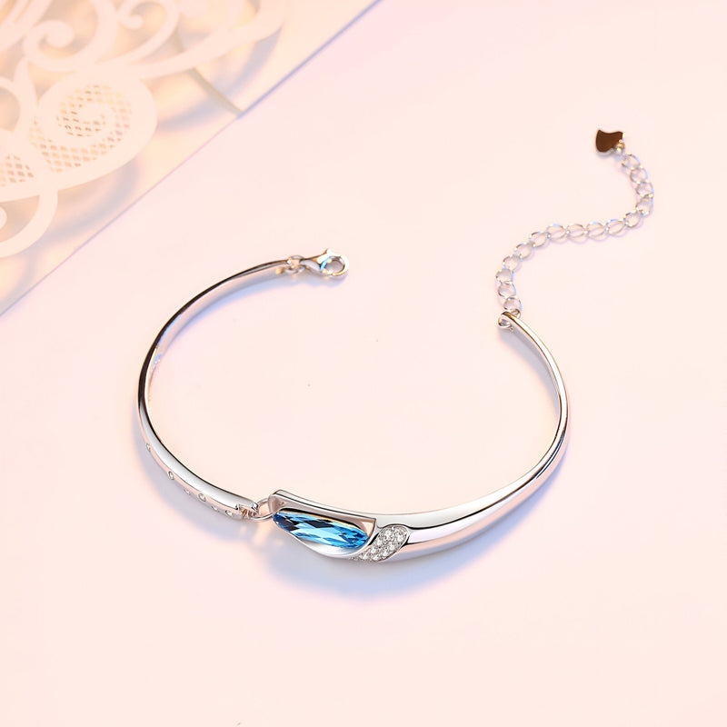 Bracelet argent sterling fin avec pierre bleue ovale élégante et chaînette ajustable.