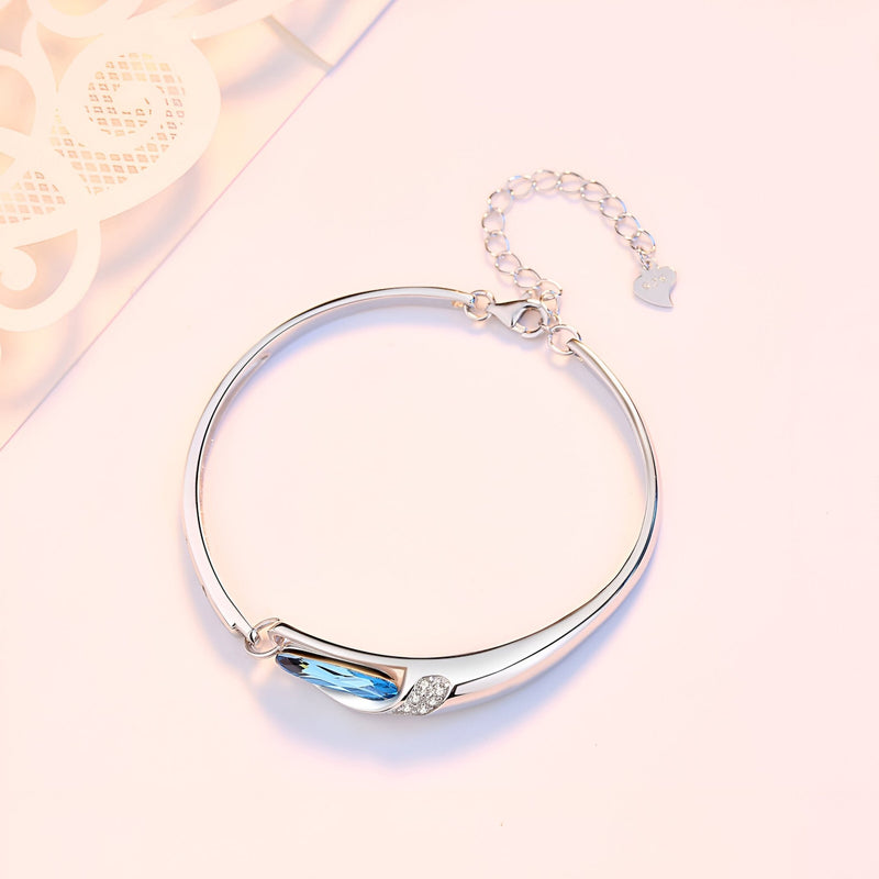 Bracelet fin en argent sterling avec pierre bleue facettée et détail de petits cristaux.