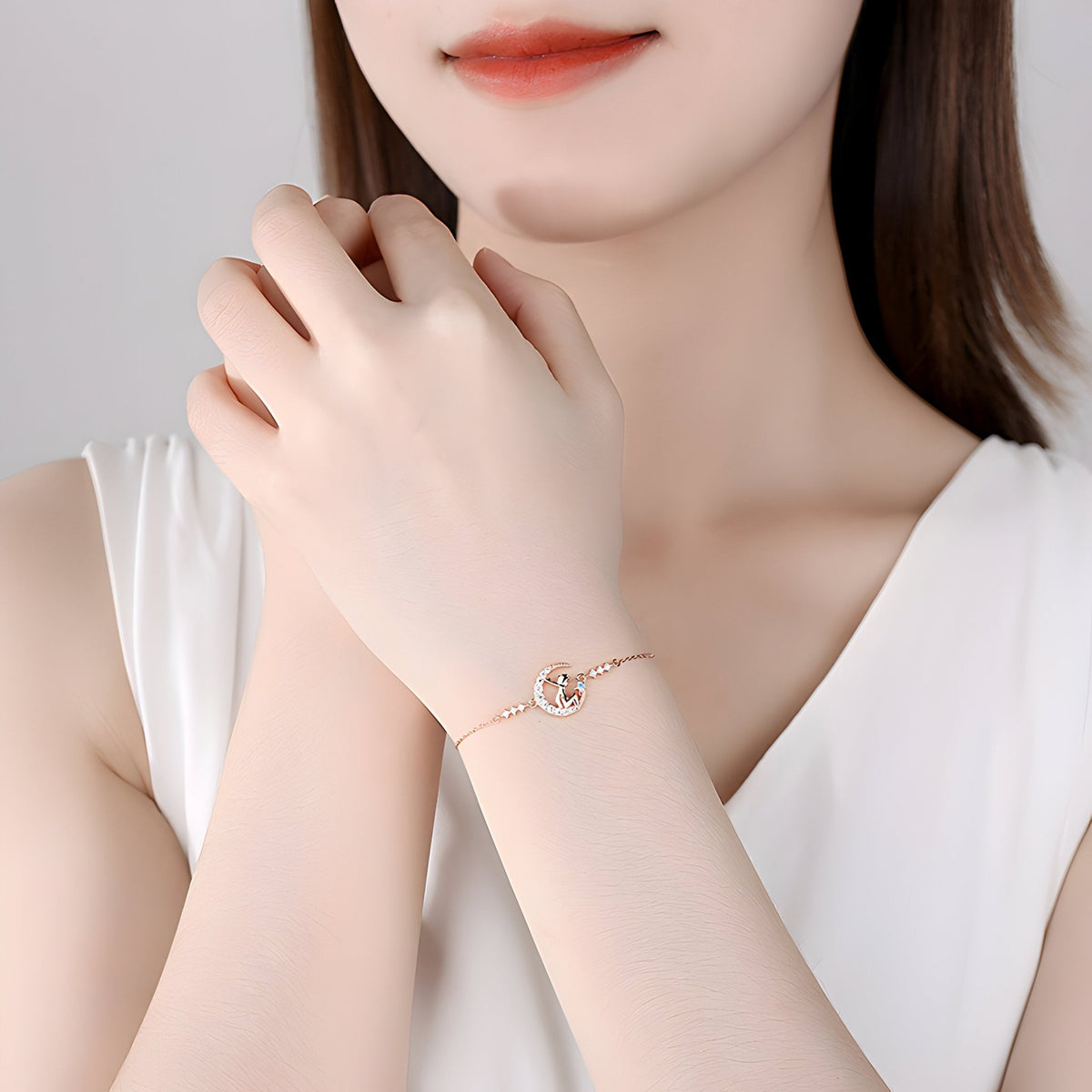 Bracelet fin en argent sterling avec pendentif Petit Prince rond délicat porté au poignet féminin.