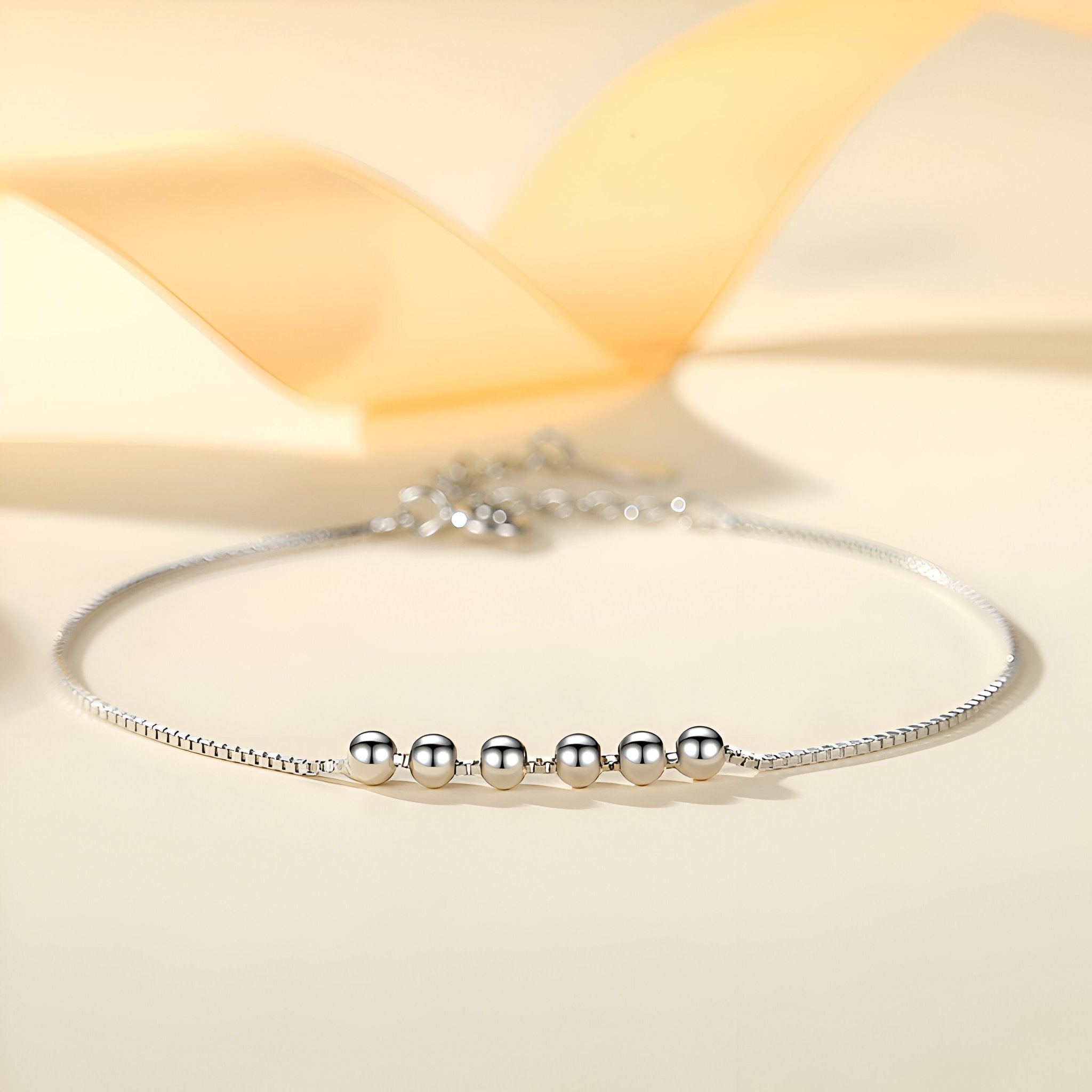 Bracelet fin en argent sterling avec cinq petites perles rondes brillantes sur chaîne délicate.