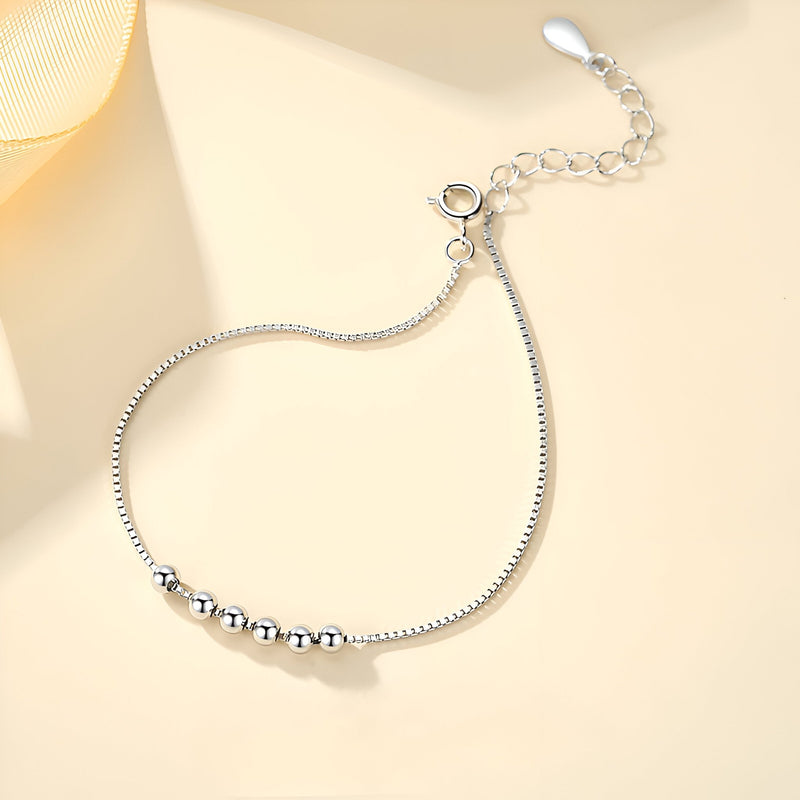 Bracelet en argent avec petites perles rondes et chaîne fine réglable.