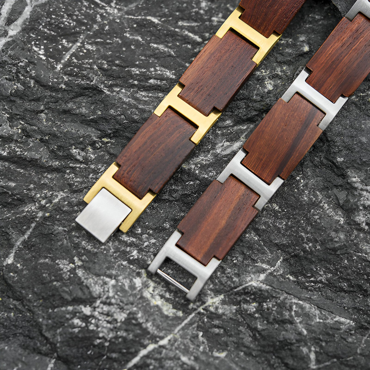 Bracelet pour homme en bois d'acajou avec fermoirs métalliques or et argent sur fond noir texturé.