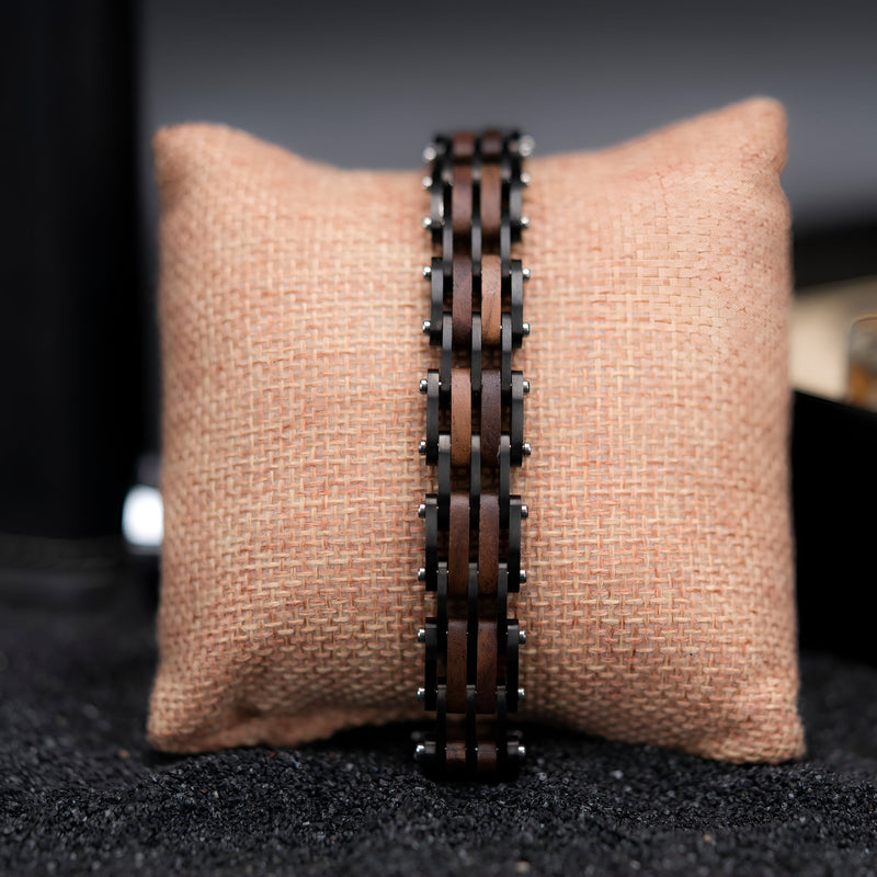 Bracelet homme en bois de noyer sombre avec maillons rectangulaires reliés par des chaînes métalliques noires.