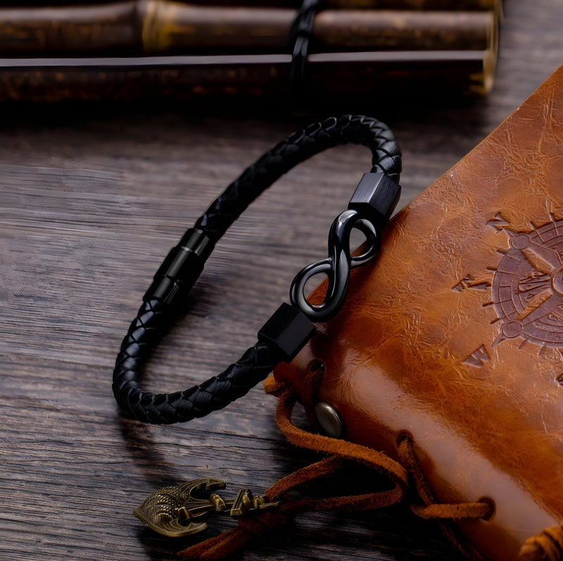 Bracelet en cuir noir tressé avec ornement infini noir mat et fermoir aimanté.