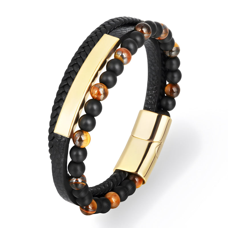 Bracelet homme en cuir noir tressé avec perles d’œil de tigre et métal doré brillant.
