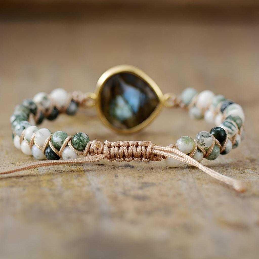 Bracelet femme pierres naturelles labradorite bleue centrale sertie or, perles blanches et vertes sur cordon beige tressé.