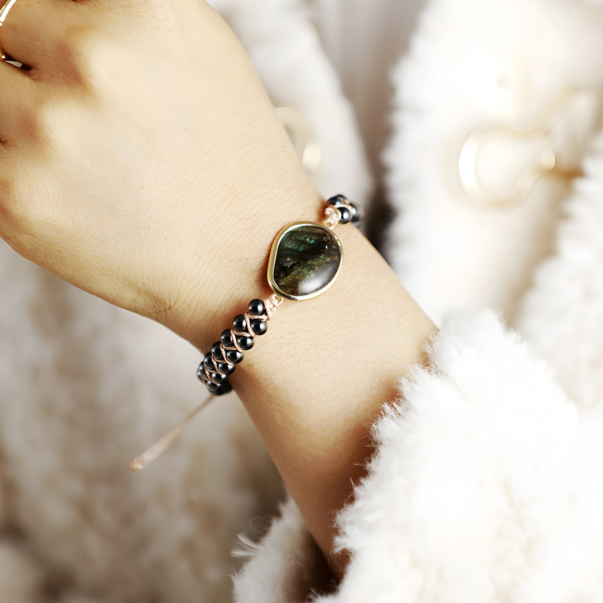 Bracelet noir multi-rangs pour femme avec pierre centrale labradorite et détails en tourmaline.