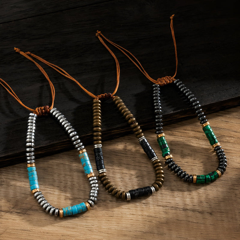 Trois bracelets pour homme avec perles en métal argenté et turquoises, cordons marron, gris et noir.