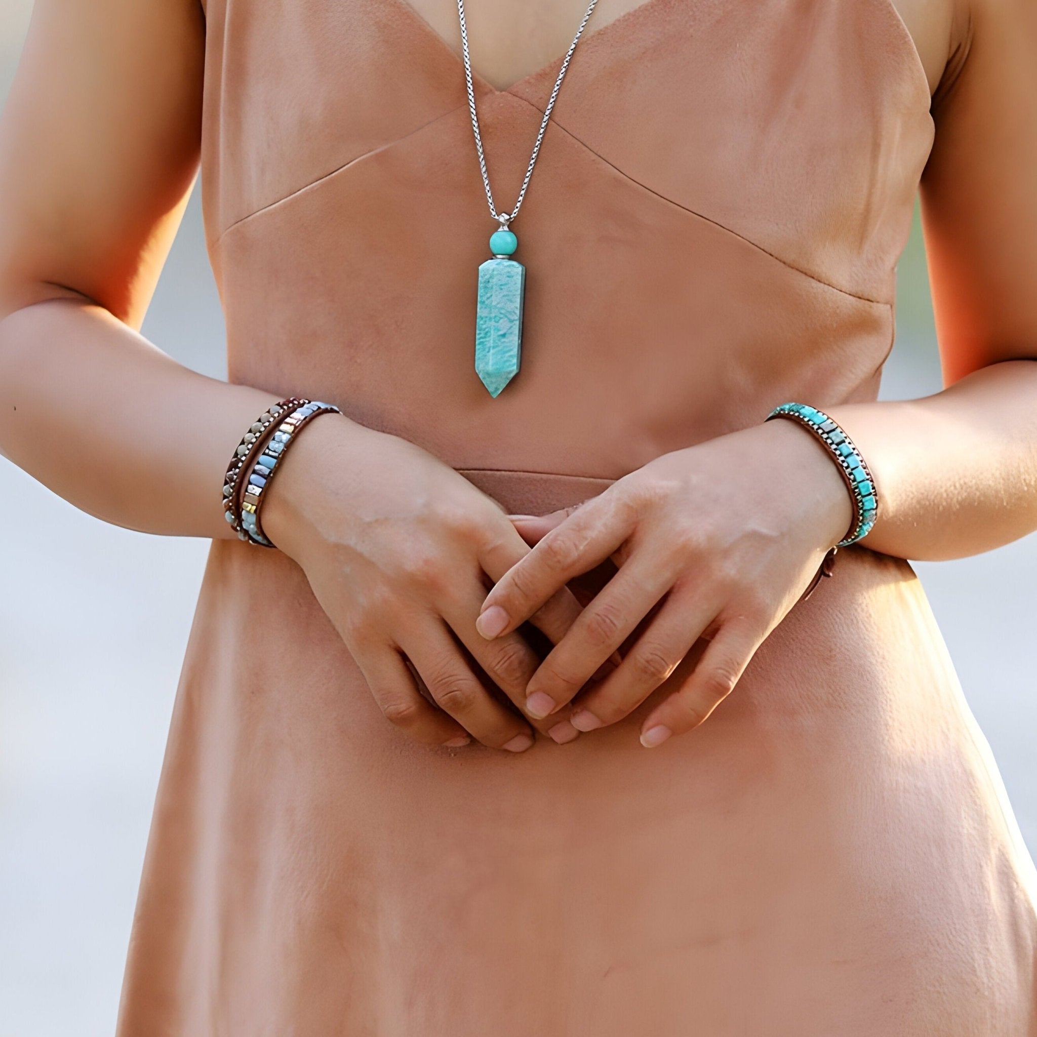 Bracelet multi-rangs en pierres turquoise et perles naturelles porté sur poignet féminin.