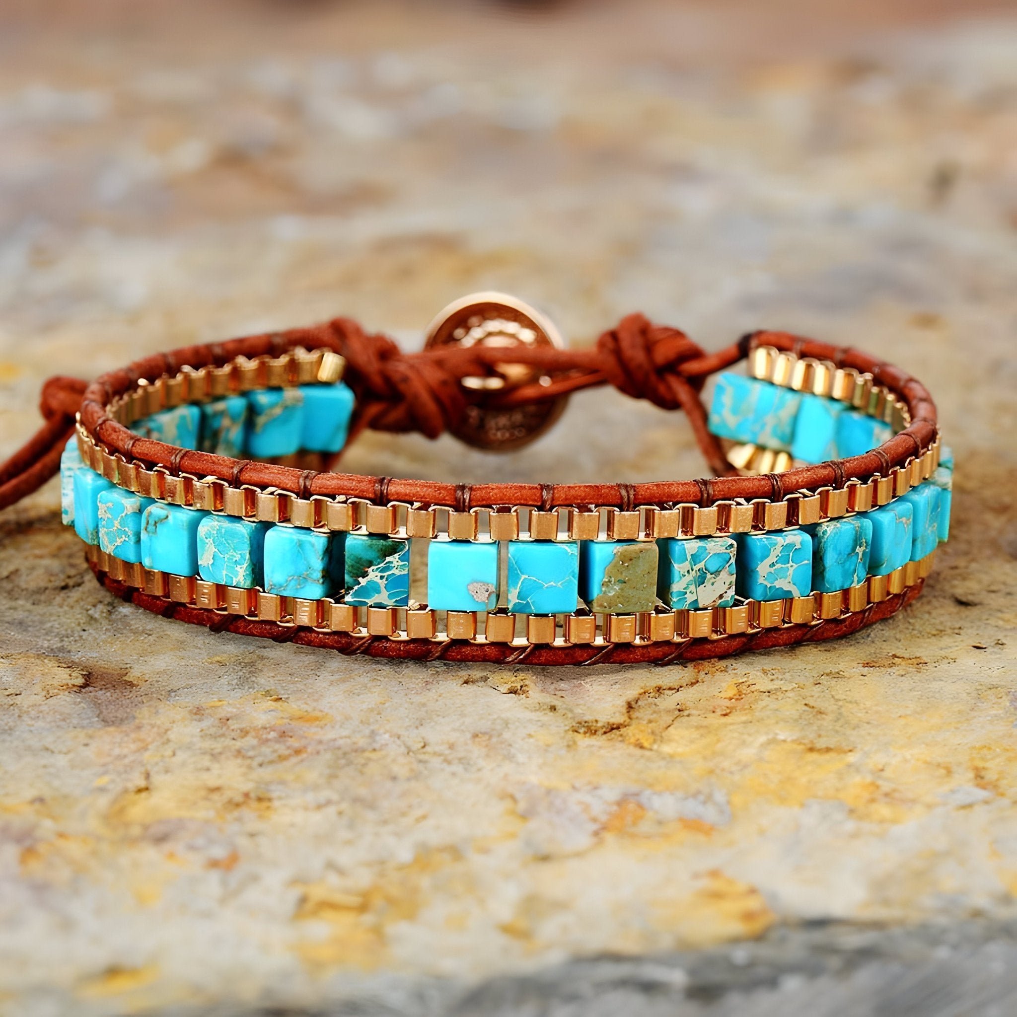 Bracelet multi-rangs en pierres turquoise carrées montées sur cuir marron avec fermoir bouton en cuivre.