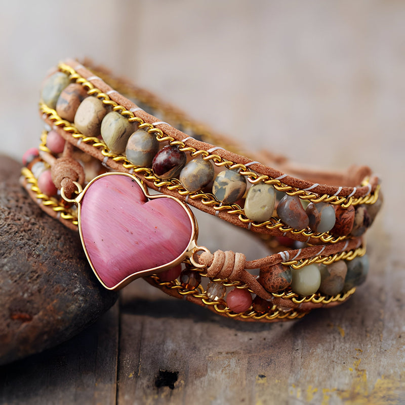 Bracelet multi-rangs en pierres naturelles multicolores avec cœur rose en pendentif et détails dorés.