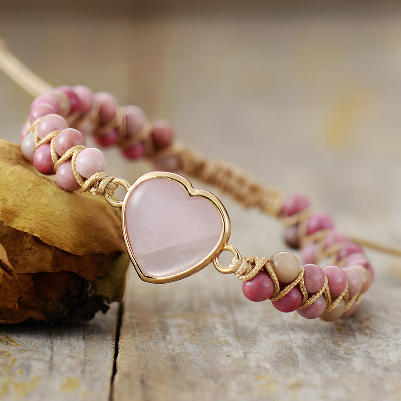 Bracelet en rhodonite rose avec pendentif cœur en quartz rose, finition dorée élégante.