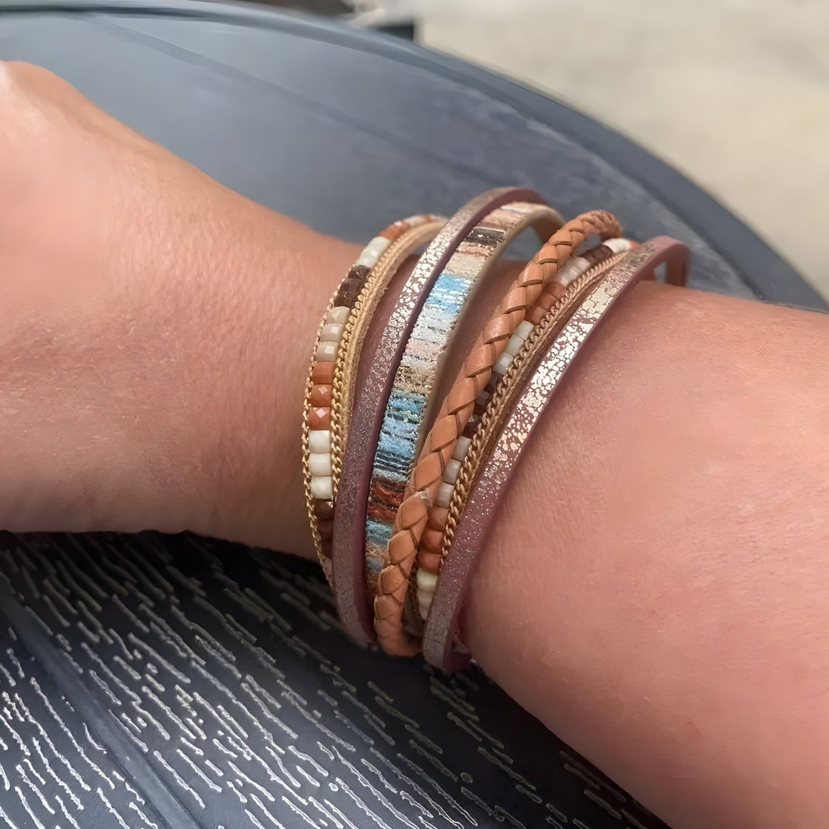Bracelet multi-rangs Louis en cuir marron tressé et lisse avec détails métalliques dorés et argentés.