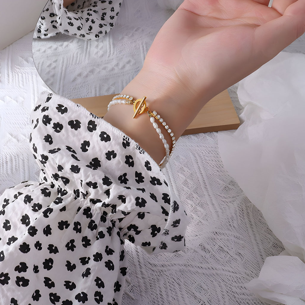 Bracelet en titane plaqué or 18 carats avec perles blanches naturelles et pierres de zircon scintillantes.